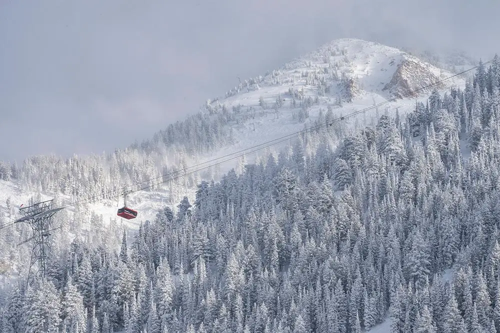 Scenic photo of the tram in a storm during winter with baldy in the back