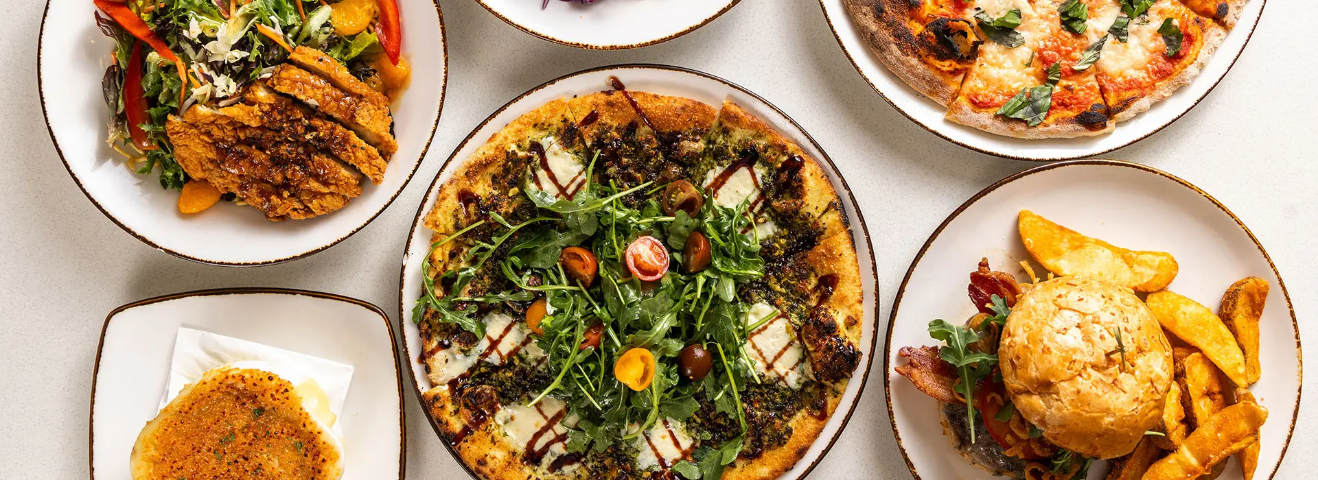 Meal spread at SeventyOne featuring salad, pizza, burgers and more- dining options at Snowbird