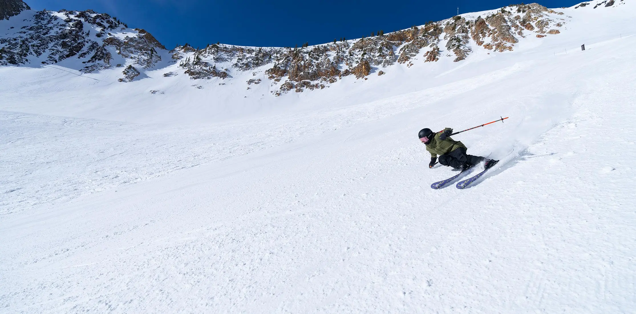 Person skiing a groomer in the sun at Snowbird
