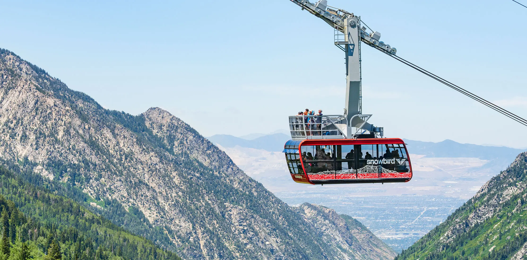 The red tram rises up the canyon at Snowbird during 4th of July weekend
