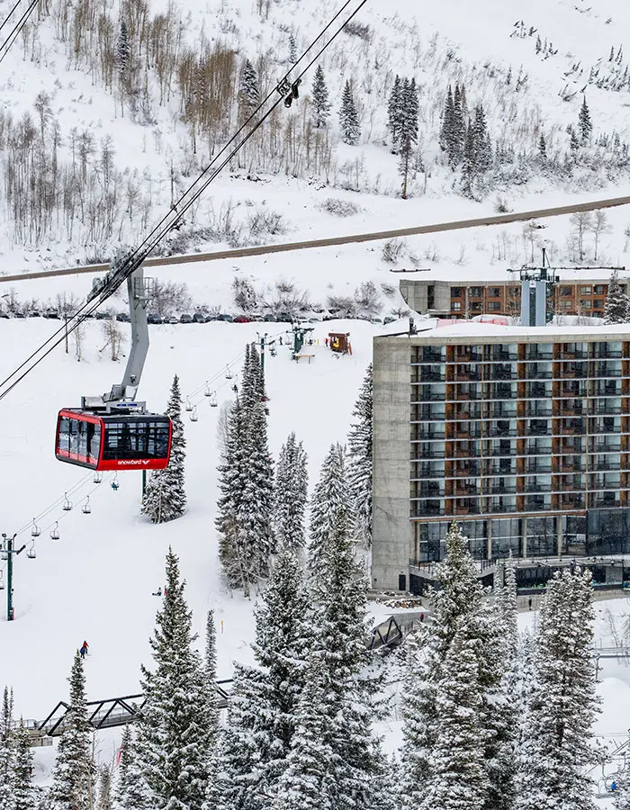 Mobile hero of the Tram rises next to the Cliff Lodge at Snowbird