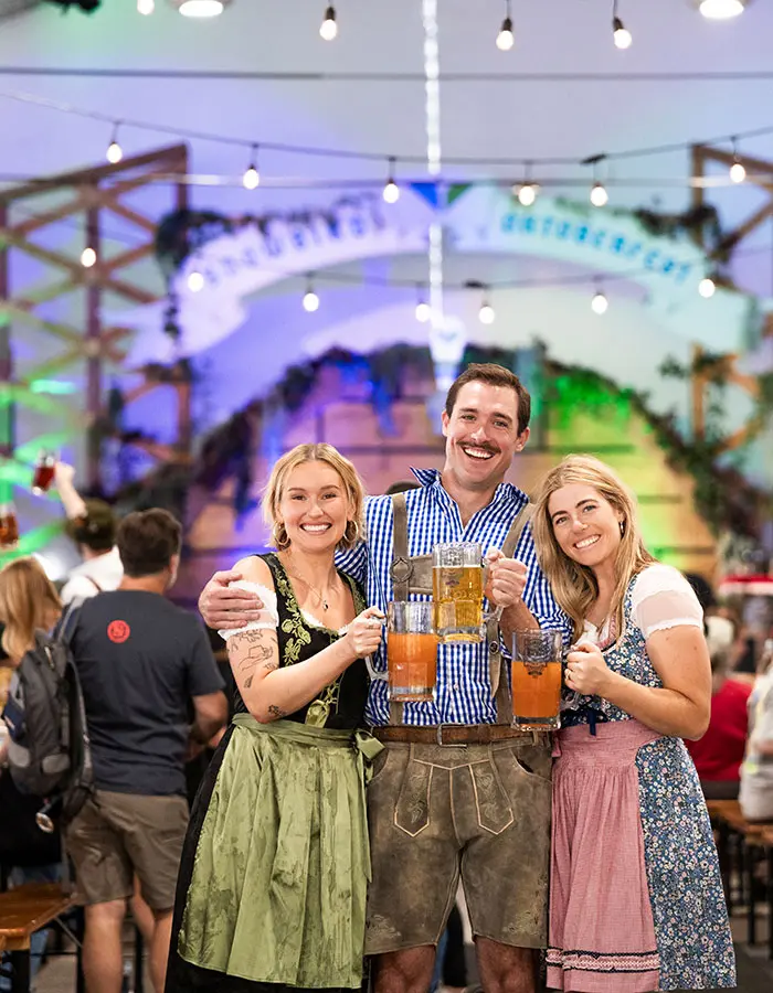Friends smile and cheers beer at Snowbird's Oktoberfest - mobile hero